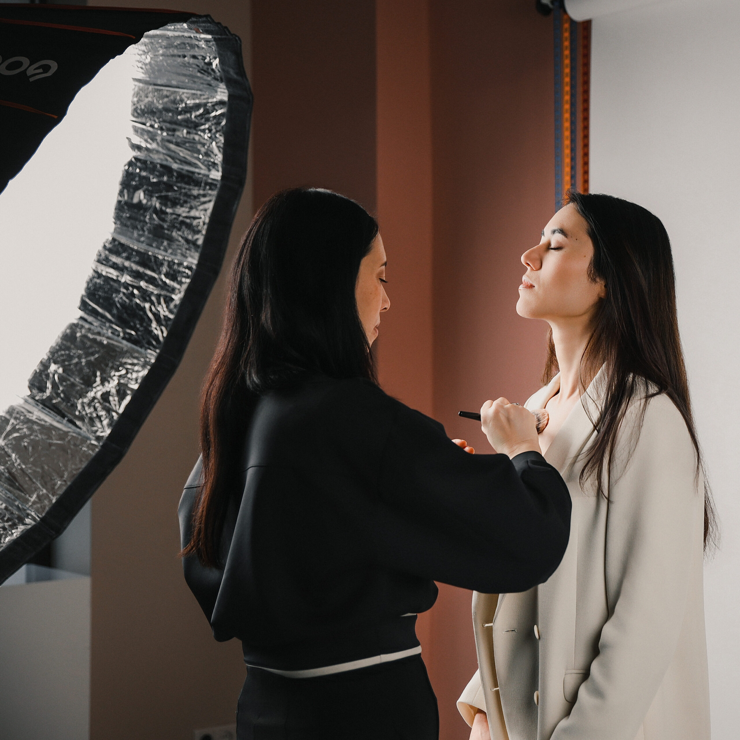 Große Godox Softboxen im Hintergrund und Make Up Artist bei der Arbeit.
