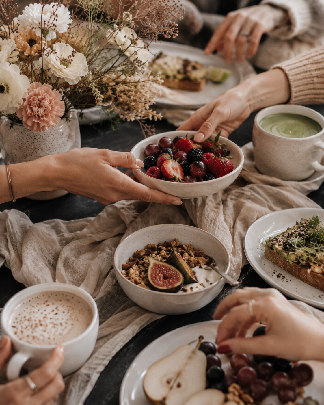 Lounge-Bereich von Beyond & Bloom mit Altbaudecke, hohen Fenstern, Balkonblick, Parkettboden, Teppich und hellen Sitzmöbeln.